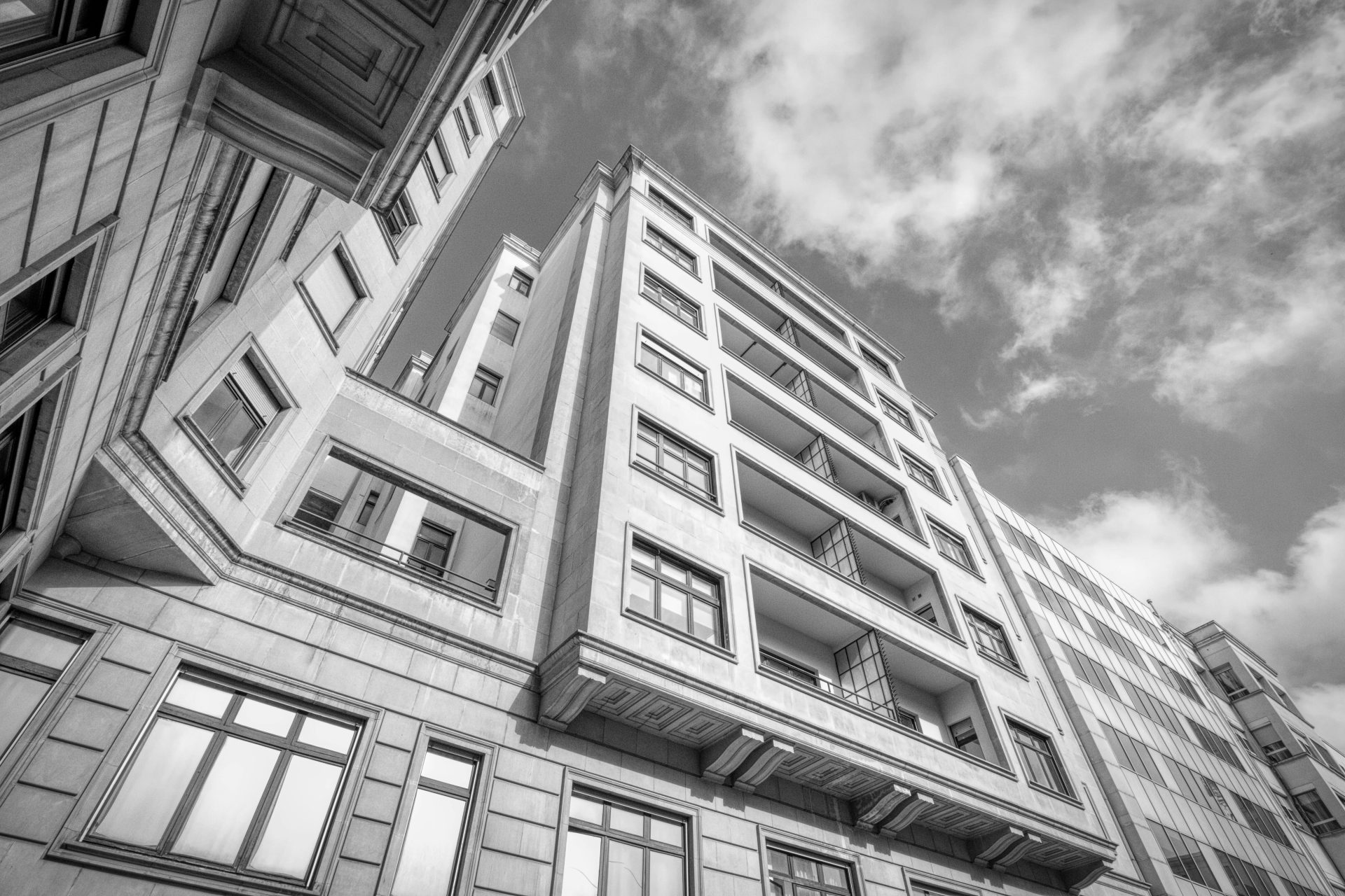 Black and white photo of a building with clouds